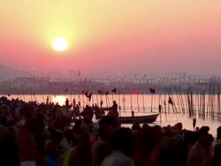 In among the riverbank crowd at sunrise as they undress and prepare for bathing in the Ganges.  Kumbh Mela, India Stock Footage