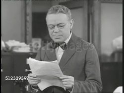 1917 DRAMATIZATION: LOCAL PAPER: INT 'The Day' newspaper office w/ editor reading part of Woodrow Wilson's speech out loud, telling them what to put on front page, 'Wilson Calls for War' Instructional Video