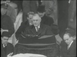 Crowds of people stand in the rain to hear President Franklin D Roosevelt's inauguration speech. News Clip