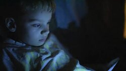 boy playing on the tablet at night Stock Footage