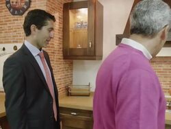 MS TS mature couple walking through display of traditional kitchen furniture, talking to salesman Stock Footage