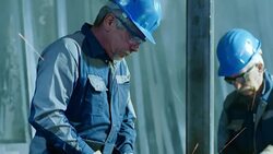 SLO MO TD Worker using an angle grinder in workshop Stock Footage