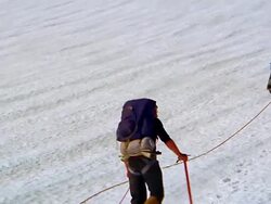 Low aerial toward and around two men walking up icy mountain-side / Olympic Peninsula, Washington Stock Footage