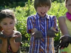 Portrait of children showing dirty hands in garden Stock Footage