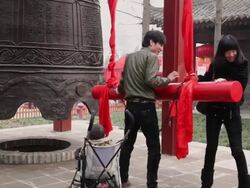 MS Couple knocking bell to pray for good luck at temple fair to celebrate Chinese spring festival / xi'an, shaanxi, china Stock Footage
