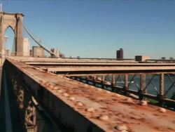 Exterior day pan from the beams of the bridge to two women walking across the Manhattan Bridge spanning the East River between Brooklyn and Manhattan  Stock Footage