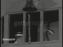 1939: NAVAL CADETS TRAINING: Young adult officer cadets marching into building. HA WS Cadets in constructed 'training' bridge, sounding bell, 'steering' ship, raising flags, giving orders to engine room, engine room responding, setting target distance Instructional Video