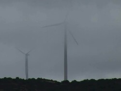 MS Shot of two wind turbines on West Texas ridge spin ghost like in clouds / Texas, United States Stock Footage
