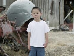Slow motion push of young boy standing showing no emotion. Stock Footage
