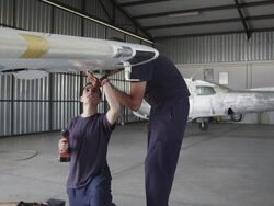 aircraft mechanics working on airplane wing in hangar, RED R3D 4K Stock Footage