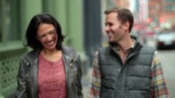 Happy New York couple walk hand-in-hand up Soho sidewalk, boyfriend stops to pull girl in for kiss Stock Footage