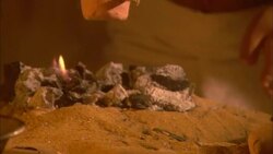 A craftsman uses tongs to place pottery onto a fire. Stock Footage