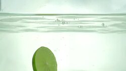 Lime slices drop in the water. Close up. Slow motion. Stock Footage