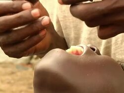 Man making mark and then cutting boy's tooth during ritual Stock Footage