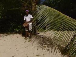 MS Man playing African drum on the beach / Brightown, Barbados Stock Footage