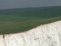 Aerials of hikers walking on East Sussex coastline News Clip