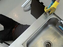 Man and woman working on kitchen plumbing Stock Footage