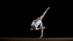 SLO MO Female gymnast doing a flip on balance beam Stock Footage