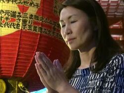 Woman praying at temple Stock Footage