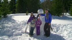HD CRANE: Family Posing With A Snowman Stock Footage