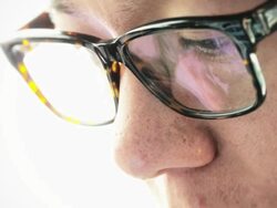 Eyes looking through a pair of glasses at digital tablet Stock Footage