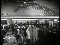 1947: U.S. AIRPLANE TERMINAL: HA WS 'Airlines Terminal' building. INT VS Travelers waiting in busy terminal, up escalators, getting off, at ticket booth, window. MS Female clerk on telephone behind booth. MS Men purchasing tickets. USA Airport Instructional Video