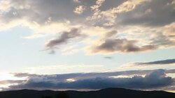 Timelapse of clouds rolling over the top of a mountain Stock Footage