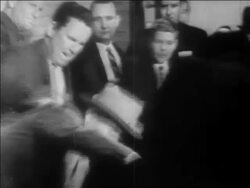 B/W 1963 Lee Harvey Oswald getting shot + killed by Jack Ruby / chaos / newsreel Stock Footage