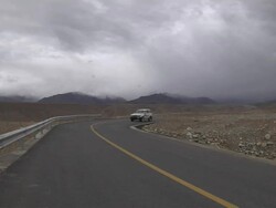 Long shot car passing on highway Taklakot Tibet China Stock Footage