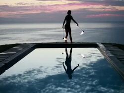 WS Woman poi dancer performing in front of pool with reflection of his silhouette in pool at sunrise / Montezuma, Costa Rica Stock Footage