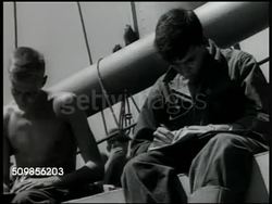 1947: U.S. OCCUPATIONAL FORCES: AERIAL: US Transport ship on ocean. American servicemen, soldiers relaxing in sun on deck. Soldier writing letter. Soldier reading magazine. BELOW DECK: Soldiers socializing in bunk area, playing cards, sharing photos. Instructional Video