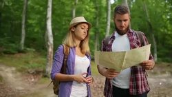 Couple Hikers making a plan with a hiking map in forest Stock Footage