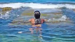 A young, attractive woman emerged in and out of the sea pool Stock Footage