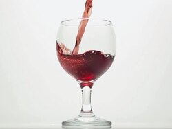 CU SLO MO Shot of Red wine being pour into glass against white background / Calvados, Normandy, France Stock Footage