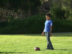 A father teaching his sons how to play American football.  - Slow Motion Stock Footage