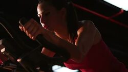 Female exercising on a bike Stock Footage