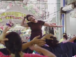 LS gymnastics trainer on stage in flower market, RED R3D 4K Stock Footage