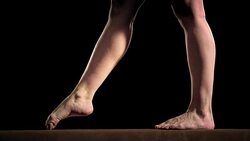 SLO MO Female gymnast doing cartwheel on balance beam Stock Footage