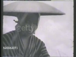 1942: JAPAN: KANTO PLAINS: * WS Wheat field w/ farmers in distance. VS Female bundling straws. VS Female stripping straw through pitchfork. WS Elderly female hammering (w/ small mallet-like tool) straws. MS Male pounding straws w/ broken bamboo. Instructional Video