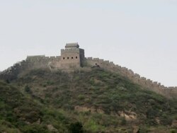 The Great Wall of China running along the the tops of green mountains.  Stock Footage