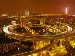 Zoom in, Nanpu Bridge, Huangpu River, night, traffic, city lights, Shanghai, China Stock Footage