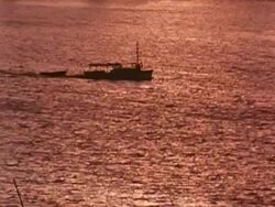 Boat in Ocean crossing frame at sunset Stock Footage
