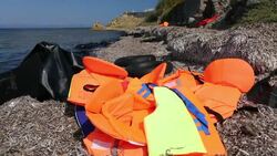 Life jackets and remains of boats left by Syrian migrants fleeing the war and escaping to Europe, landing on the Greek island of Lesvos on the north coast at Efthalou. Up to 4,000 migrants a day are landing on the island and overwhelming the authorities. T Stock Footage