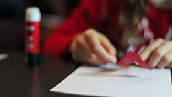 Girl putting glue on a number 1 and gluing on a sheet. Stock Footage