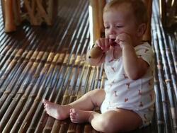 MS Shot of baby sitting up and playing / Ubud, Bali, Indonesia Stock Footage
