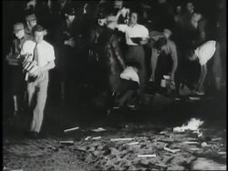 Nazi Germans throw books onto a bonfire, giving the fascist salute. News Clip
