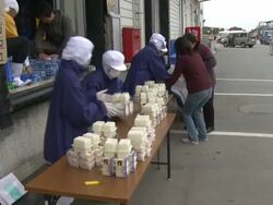 Aftermath of tsunami after magnitude 9 Tohoku earthquake, north east Japan, March 2011. People gather supplies at tofu factory in Osaki city after tsunami Stock Footage