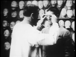 B/W 1910s man attaches prosthetic mask to World War I veteran with severely disfigured face / newsreel Stock Footage