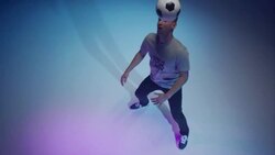 Young male soccer freestyler juggling a ball around his head Stock Footage