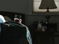 woman lying down passed out holding a glass of alcohol Stock Footage